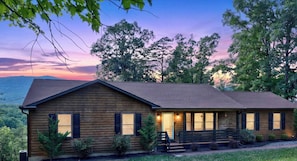 A wooden cabin with a porch, windows, and a door.