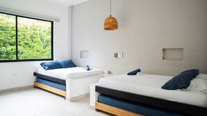 Een moderne hotelkamer met twee bedden, een groot raam en een hanglamp.