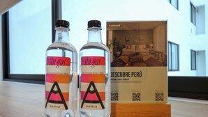 Twee flessen 'sin-gas' met een QR-code en een brochure met de titel 'DESCUBRE PERÚ' op een houten ondergrond.