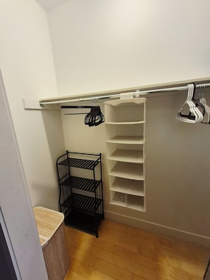 Un placard de rangement avec des étagères, une étagère métallique et une tringle pour suspendre les vêtements.