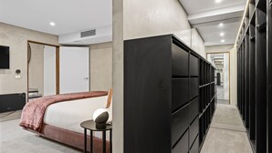 A modern hotel room with a bed, a TV, a wardrobe, and a small table. - Corten Haus South Urban Retreat (South Melbourne)