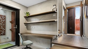 A modern office space with a desk, chair, and built-in shelves. - Corten Haus South Urban Retreat (South Melbourne)
