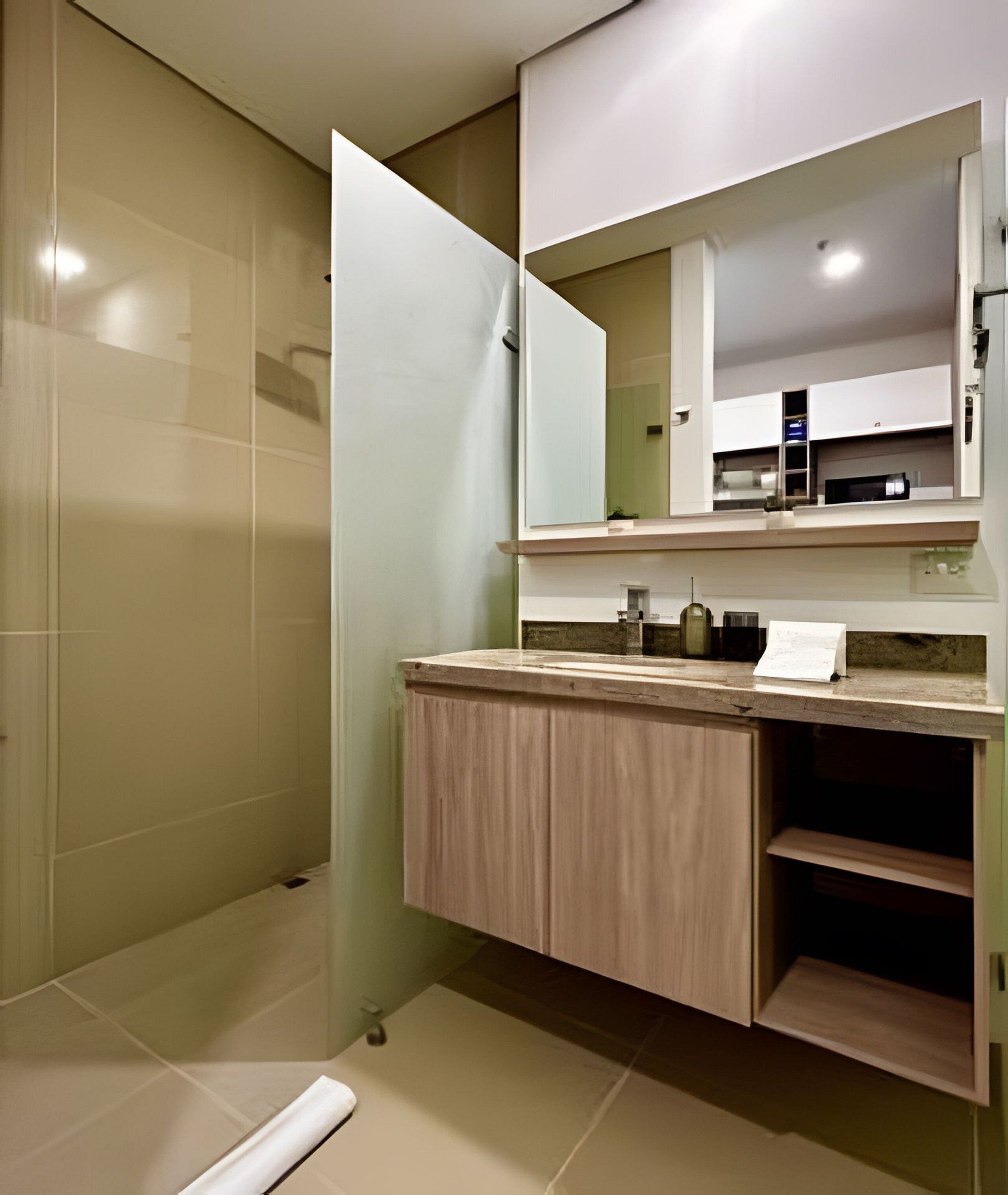 A modern bathroom with a glass shower enclosure, a wooden vanity with a mirror, and a tiled floor.