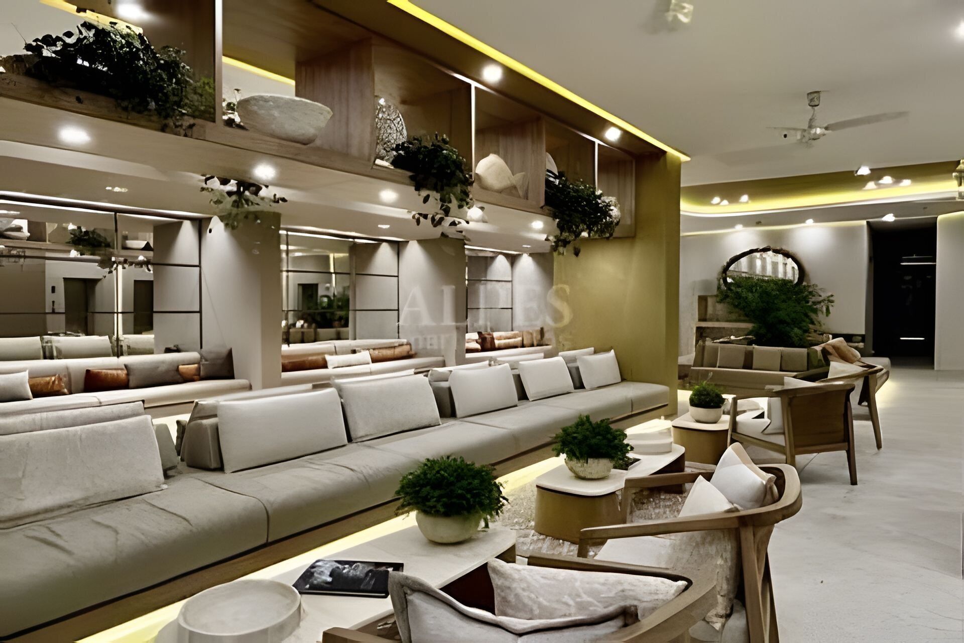 A modern living room with a sofa, armchairs, and a coffee table. There are plants and decorative items on shelves.