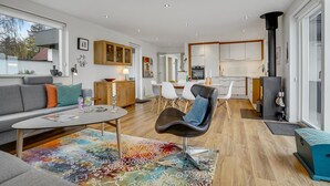 Ein modernes Wohnzimmer mit einer Couch, einem Couchtisch und einem farbenfrohen Teppich.