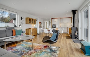 Ein modernes Wohnzimmer mit einer Couch, einem Couchtisch und einem farbenfrohen Teppich.