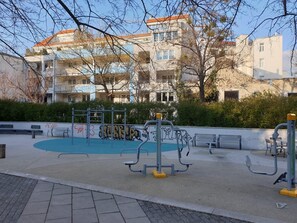 An outdoor exercise area with benches and fitness equipment, surrounded by apartment buildings. - Apartment Sleeps 6 with Garden & Balcony (Wien)