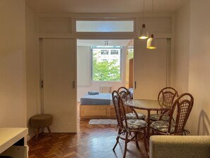 Ein Essbereich mit Tisch und Stühlen, einer Bank und einem Fenster mit Blick ins Grüne.