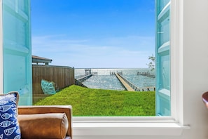 Una habitación con un ventanal grande con vista a un muelle y al agua.