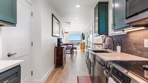 Una cocina moderna con horno empotrado, microondas y un amplio ventanal.