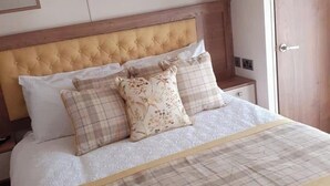 Ein Bett mit einer gebügelten Kopfteil, mehreren Kissen und einer Bettdecke.