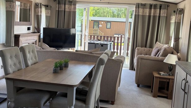 Ein geräumiger Wohnbereich mit Esstisch, Sofas und einem Fernseher.