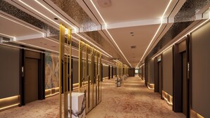 A modern hotel hallway with a marble floor, illuminated by linear lights, and featuring a central column with a marble sculpture. - BTC hotel (Malacca City)