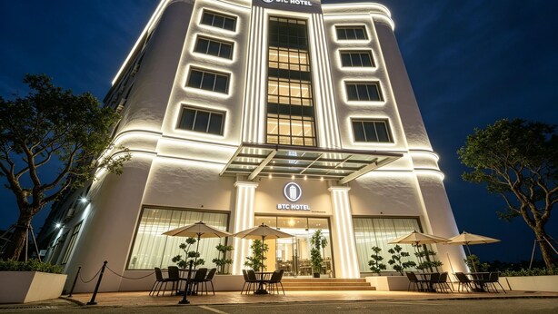 A modern hotel with a prominent entrance, large windows, and outdoor seating. - BTC hotel (Malacca City)