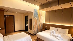 A hotel room with two beds, a large mirror, and a modern ceiling design. - BTC hotel (Malacca City)