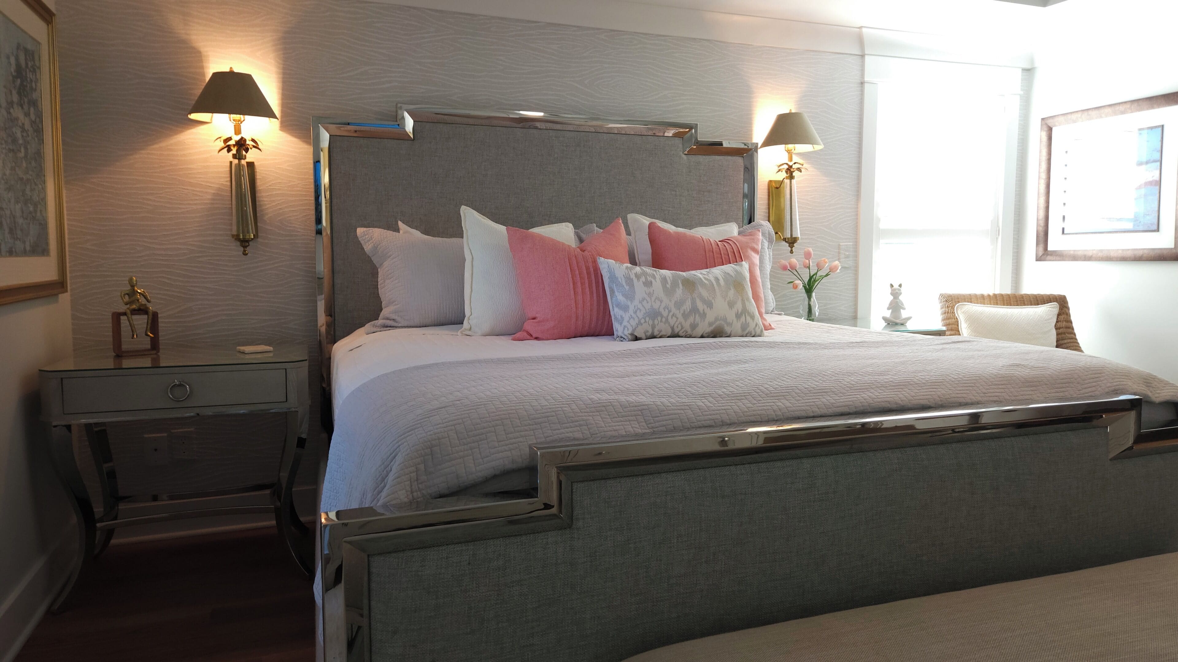 A neatly arranged bedroom with a bed, bedside tables, lamps, and a small decorative item on the nightstand.