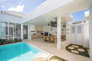 A modern outdoor living area with a pool, a covered patio, and a kitchen. - VON Hideaway Uluwatu (Ungasan)