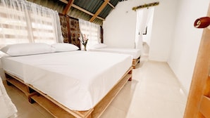 A room with a large bed, a smaller bed, and a wooden bench. - Tranquilidad Cabin, Left Hemisphere (San José Del Guaviare)