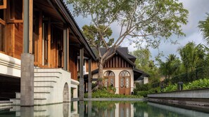 Una piscina al aire libre, sombrillas, sillones reclinables de piscina