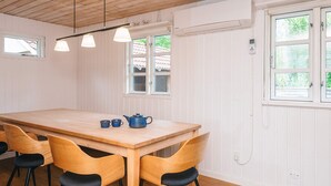 En matplats med ett träbord, fyra stolar och en blå tekanna.