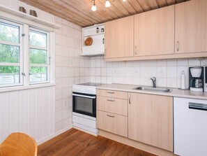 A kitchen with white cabinetry, a built-in oven, a sink, and a coffee maker. - 5 Person Holiday Home in Herning (Herning)