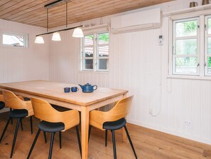 En matplats med ett träbord, fyra stolar och en blå tekanna.
