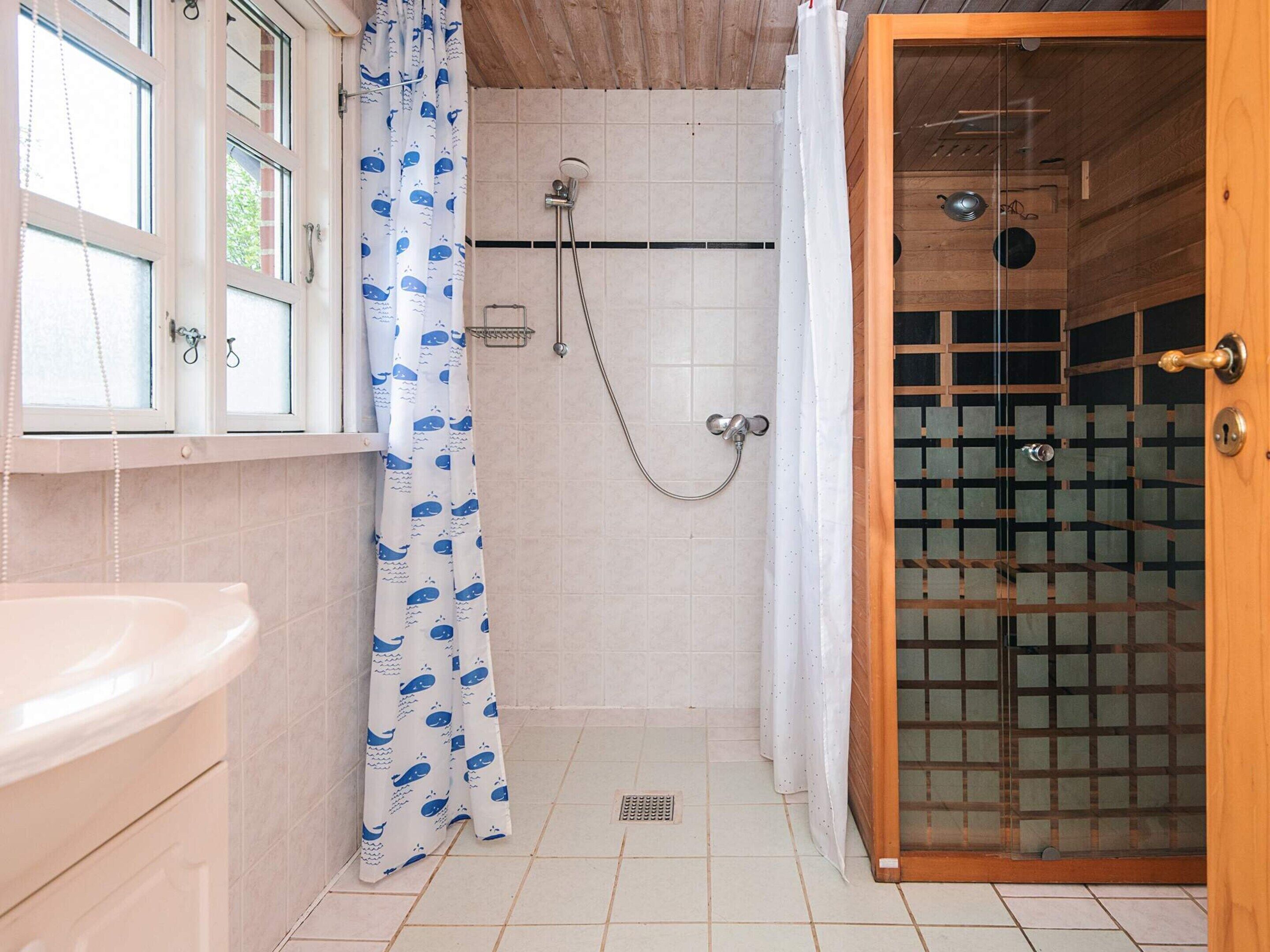 A bathroom with a shower, a toilet, and a sink.
