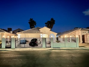Ein Wohngebiet mit geschlossenem Tor, Garage, Auffahrt und einem Haus mit Ziegeldach.