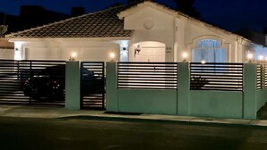 A residential building with a tiled roof, a garage, and a gated entrance. - Private 2BR Home Near the Las Vegas Strip, Wi-Fi, Laundry and Parking. (Las Vegas)