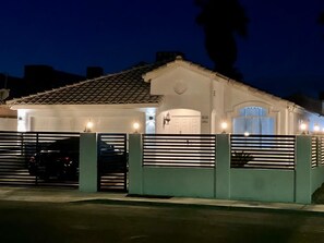 Ein Wohngebäude mit Ziegeldach, Garage und geschlossenem Eingangstor.