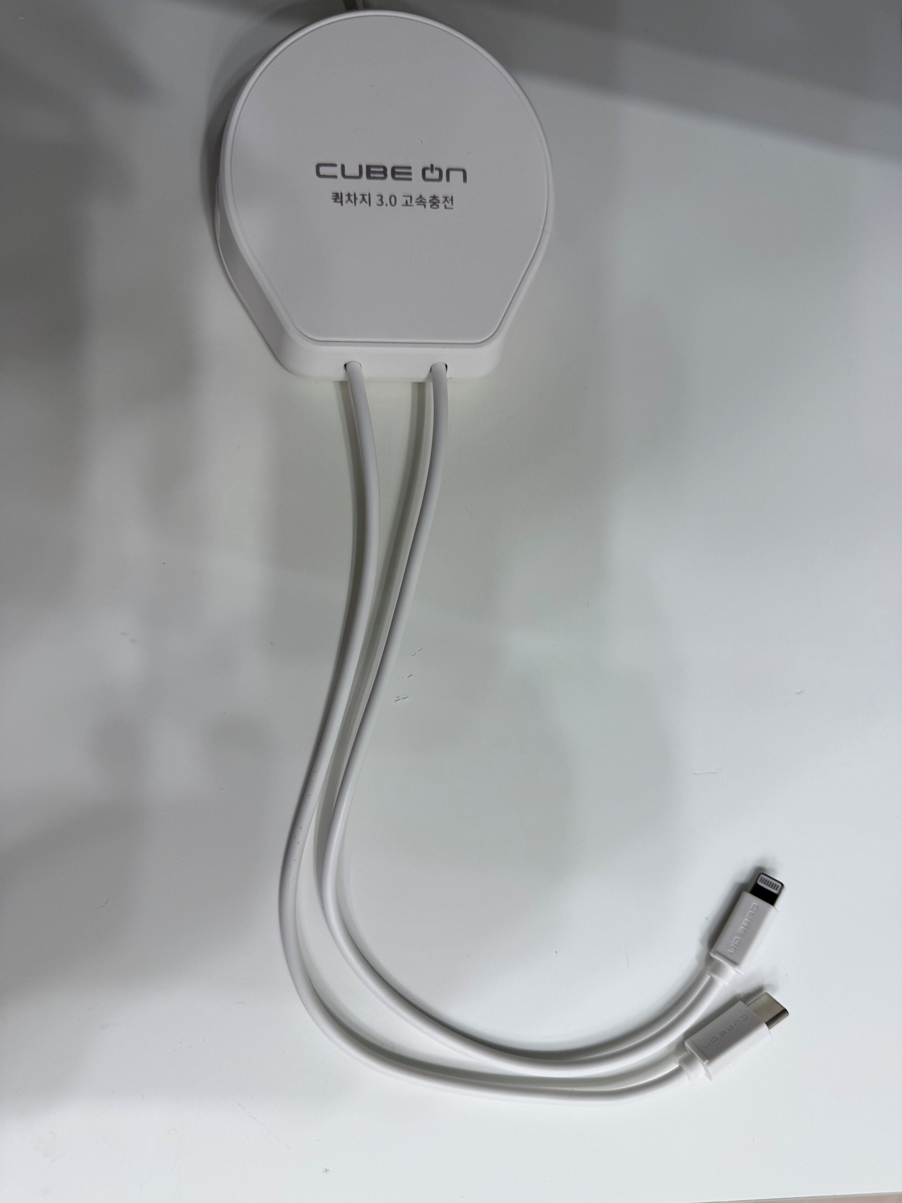 Ein weißes Gerät mit zwei Kabeln und einem USB-Anschluss, beschriftet mit 'CUBE ON' und 'KRZCHZ 3.0'.