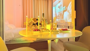 A hotel room with a bed, a dining table with candles, bottles, and fruits. - Esanghan Stay Suwon Ingye (Suwon)