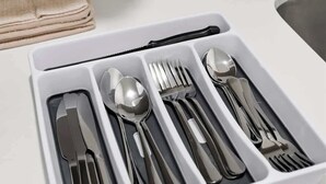Una bandeja blanca con cubiertos, incluyendo cuchillo, cuchara, tenedor y otra cuchara.