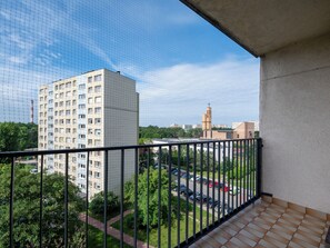 A balcony with a view of a parking lot and buildings.
