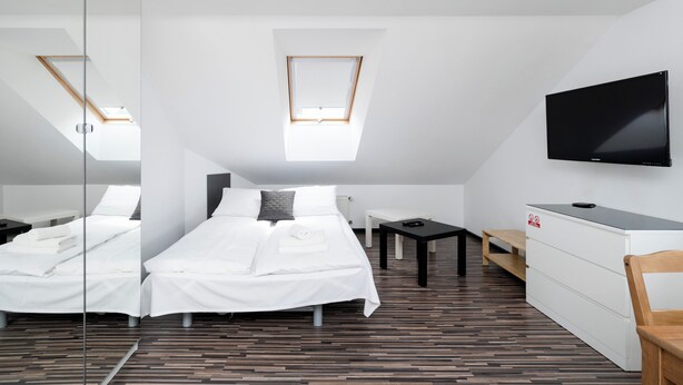 Ein modernes Hotelzimmer mit einem großen Bett, einem Schreibtisch, einem Fernseher und einem Oberlicht.