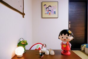 Ein Esstisch mit dekorativer Lampe, einer kleinen Figur, einem Teekännchen und einer Keramiktasse.