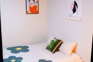 Ein Schlafzimmer mit einem Bett, Kissen und zwei Wandbildern.
