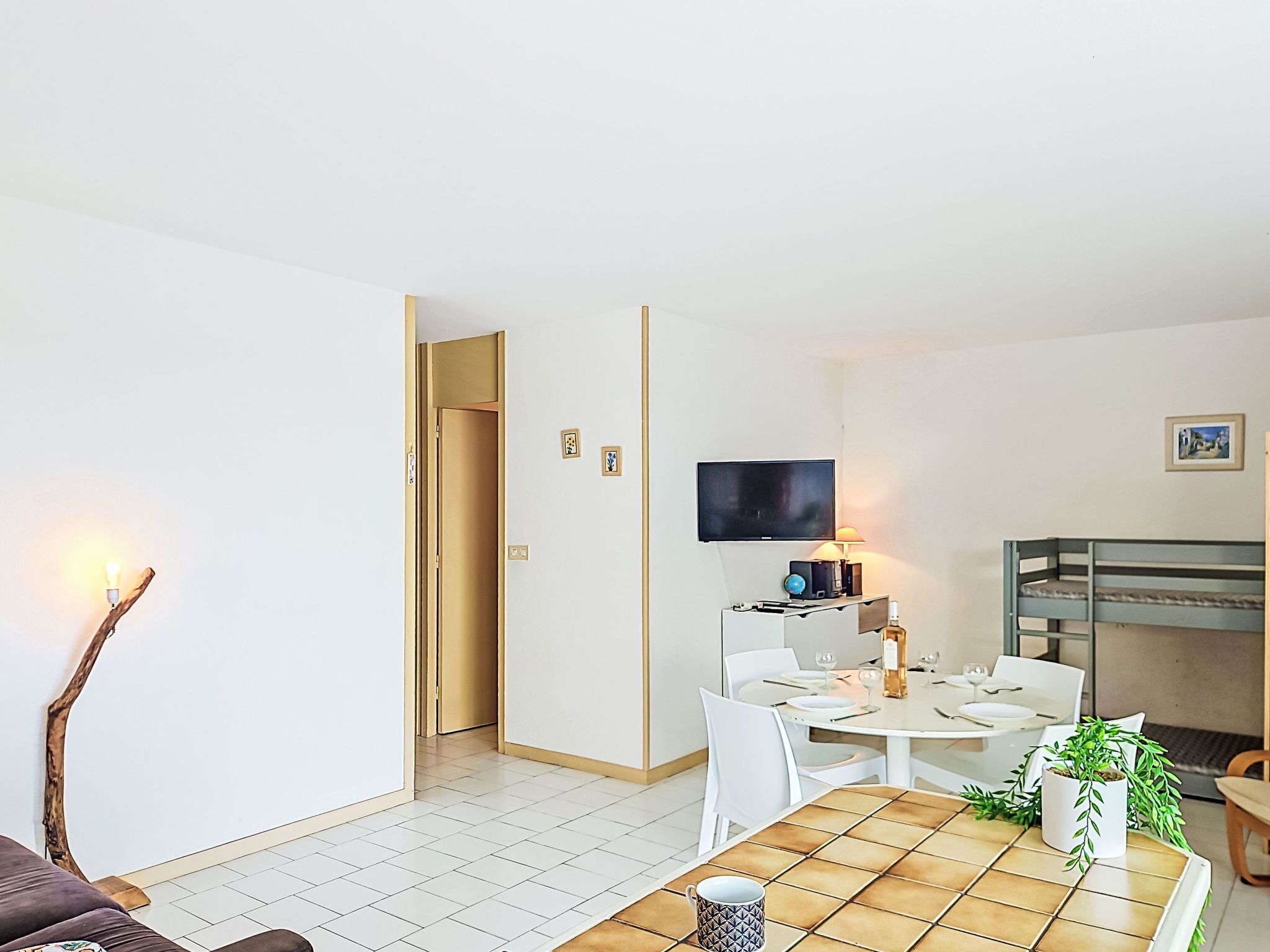 Una sala de estar moderna con televisión, mesa de comedor y sofá.