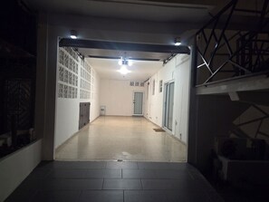 A hallway with a tiled floor, a door at the end, and a staircase on the right.
