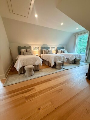 A bedroom with two beds, a large window, and a wooden floor. - King & Queen-King Unit I (Auburn)