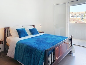 A bed with a blue blanket, white pillows, and a wooden headboard. - Les Dunes by Interhome (Mimizan)