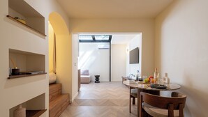 Ein modernes Interieur mit Essbereich, Holzböden und einer Treppe zu einer oberen Ebene.