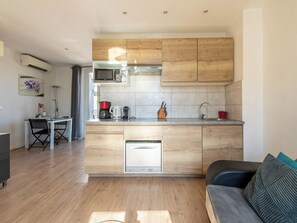 Eine moderne Küche mit Holzausstattung, einer eingebauten Mikrowelle und einer Kaffeemaschine.