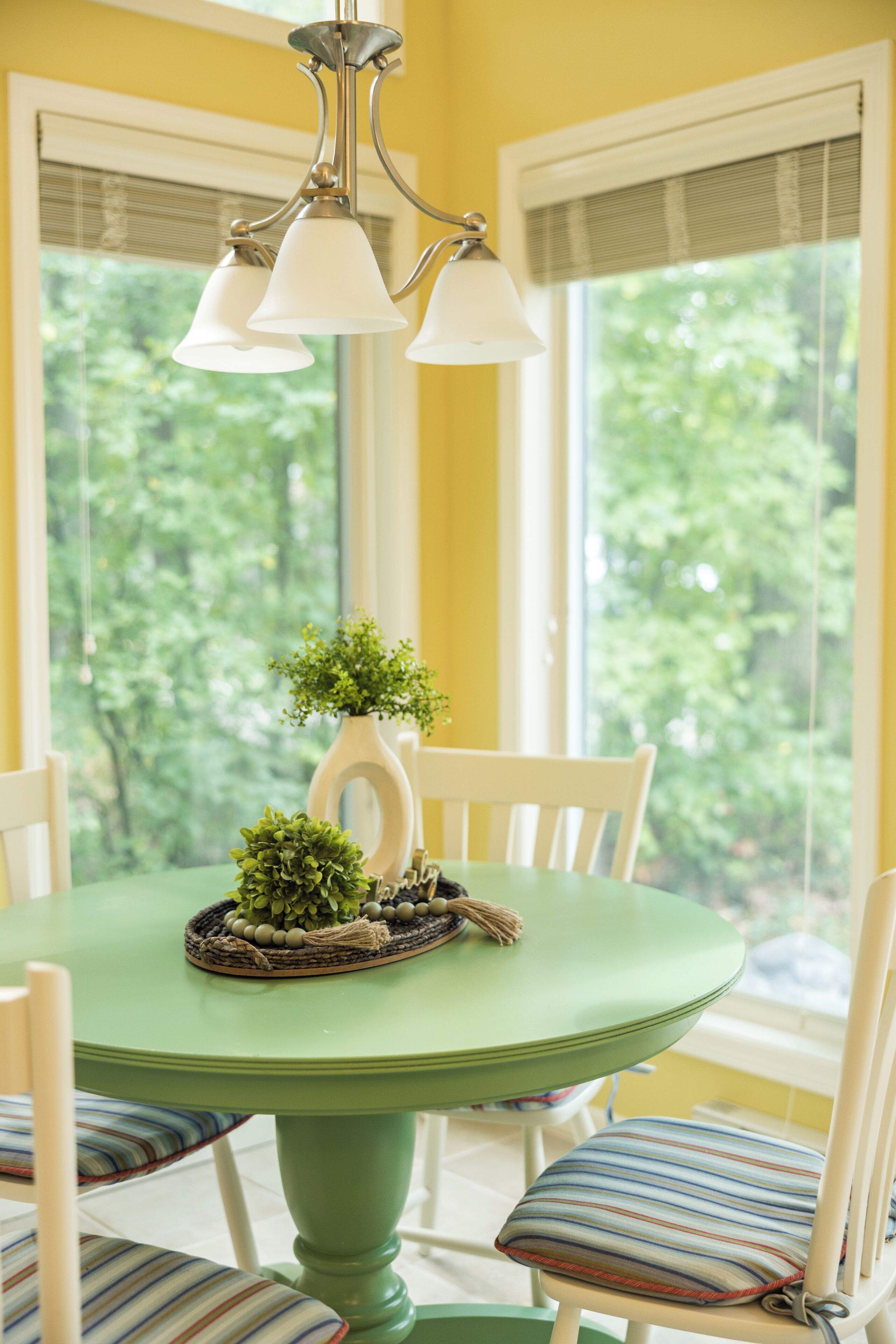 Une table à manger avec des chaises, une plante en pot et un objet décoratif posé sur la table.