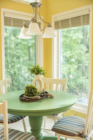 Une table à manger avec des chaises, une plante en pot et un objet décoratif posé sur la table.