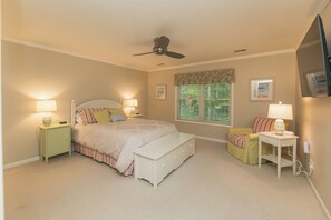 A bedroom with a bed, bedside tables, a desk, a chair, a ceiling fan, and a window with blinds. - Hot Tub-Game Room-Sun Room-Backyard-King-7 TVs-5 Bedrooms-4300 SqFt. Sleeps 12 (Honor)