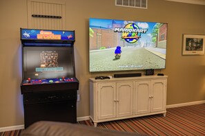 A gaming console with a display screen and a television mounted on the wall. - Spacious 5-bedroom near Sleeping Bear Dunes/beaches - New Owner Special Pricing (Honor)