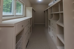 A narrow hallway with built-in storage cabinets on both sides and a window at the end. - Hot Tub-Game Room-Sun Room-Backyard-King-7 TVs-5 Bedrooms-4300 SqFt. Sleeps 12 (Honor)
