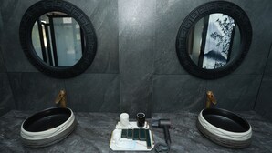 A bathroom with two sinks, each with a round mirror, and a central vanity with a towel rack and a hairdryer. - BX Star River Hotel (Lijiang)