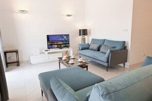 A modern living room with a flat-screen TV, a sofa, a coffee table, and a lamp. - Yacht Marina View - Modern 3 bdrs Apart M, Msida, Malta (Msida)